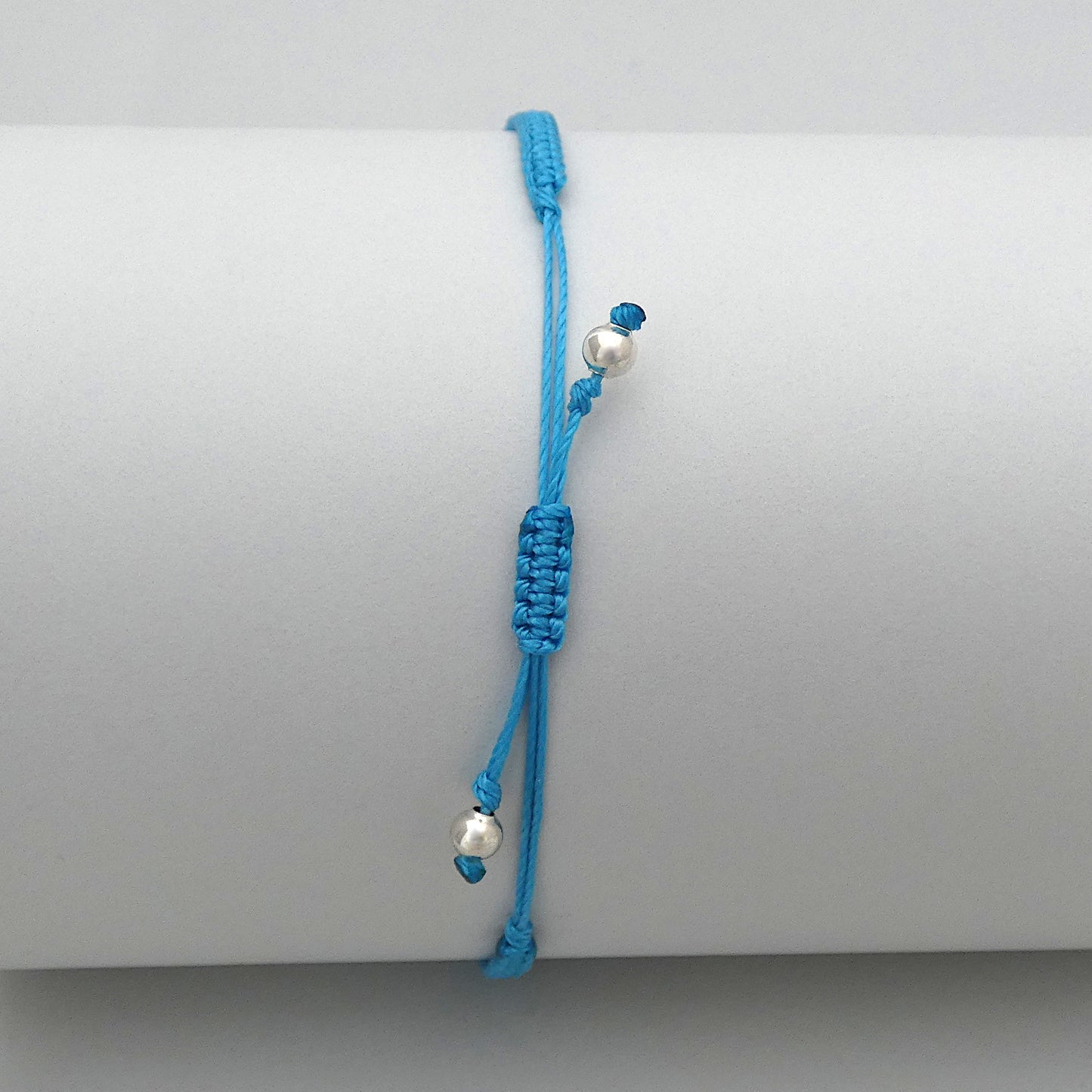7” adjustable Bermuda blue macramé bracelet for adults with silver plated bead ends.