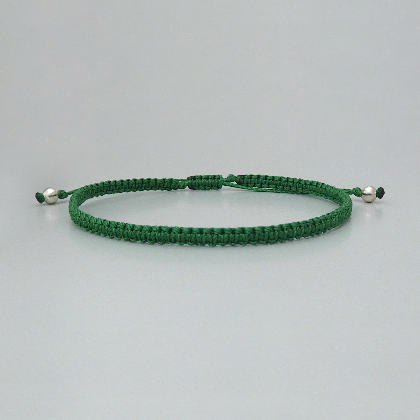 7” adjustable Christmas green macramé bracelet for adults with silver plated bead ends.