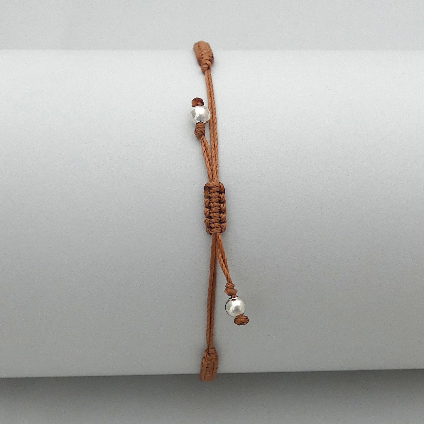 7” adjustable copper coloured macramé bracelet for adults with silver plated bead ends.