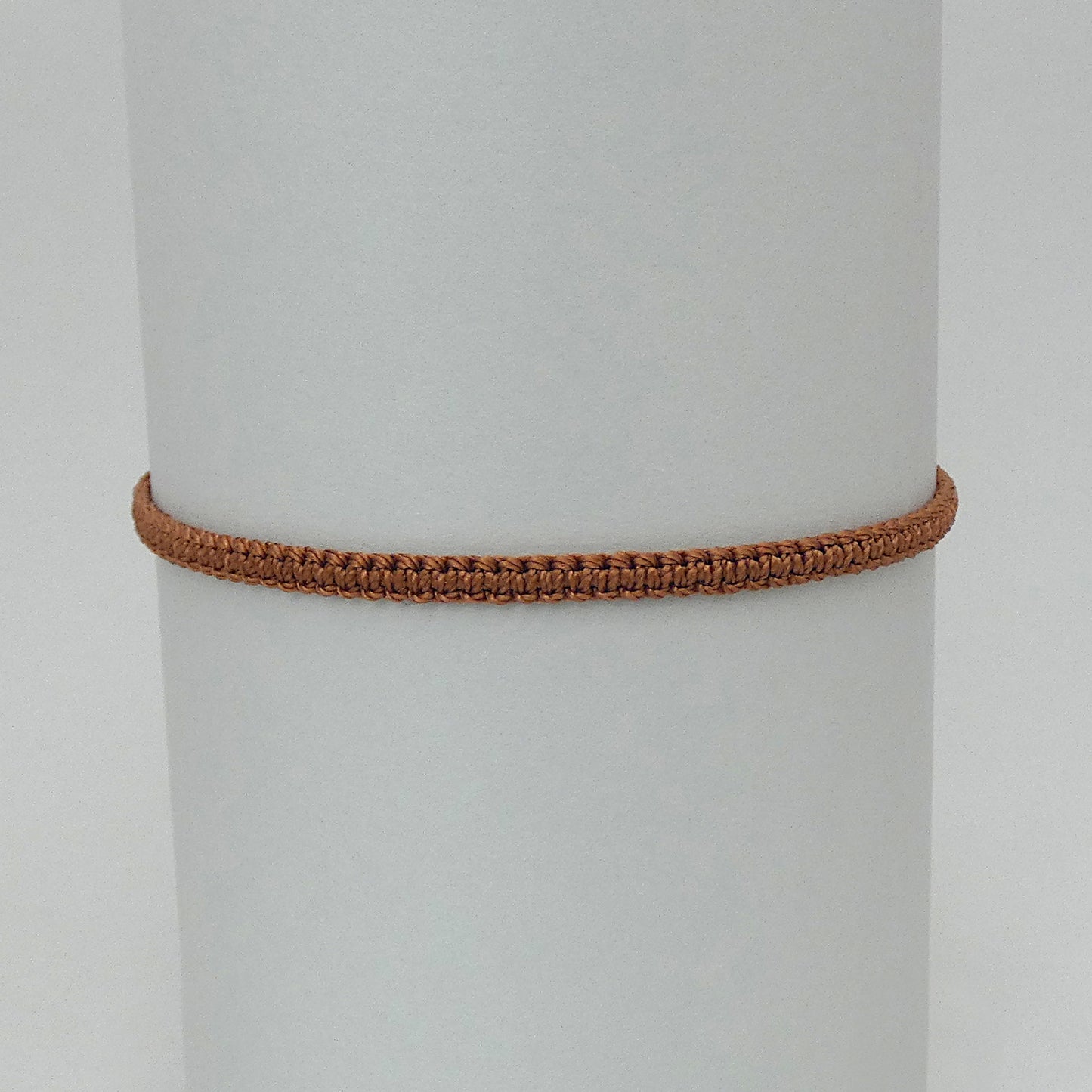 7” adjustable copper coloured macramé bracelet for adults with silver plated bead ends.