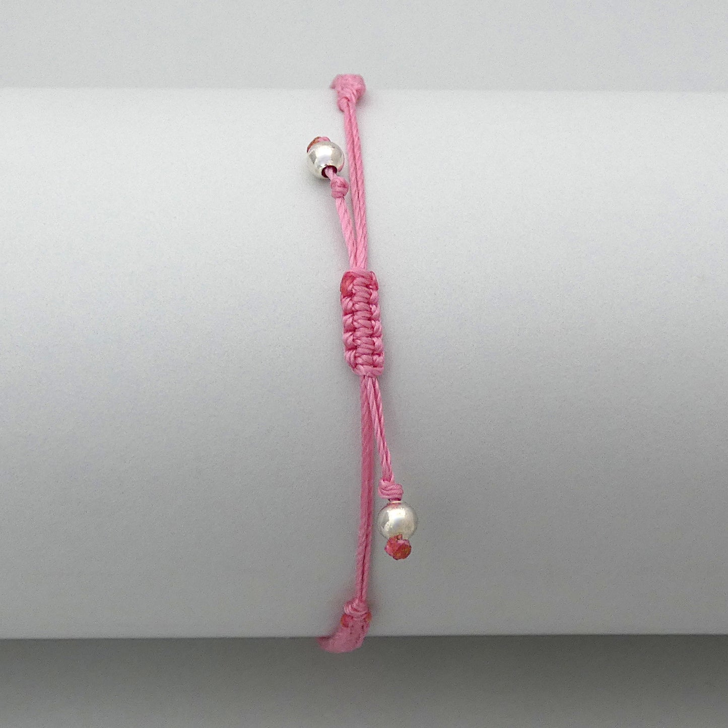 7” adjustable pink coloured macramé bracelet for adults with silver plated bead ends.