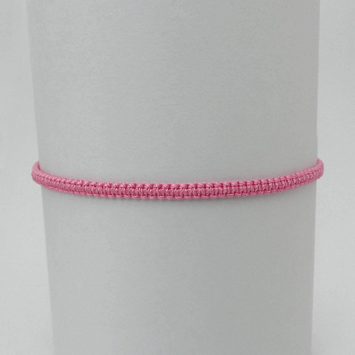 7” adjustable pink coloured macramé bracelet for adults with silver plated bead ends.