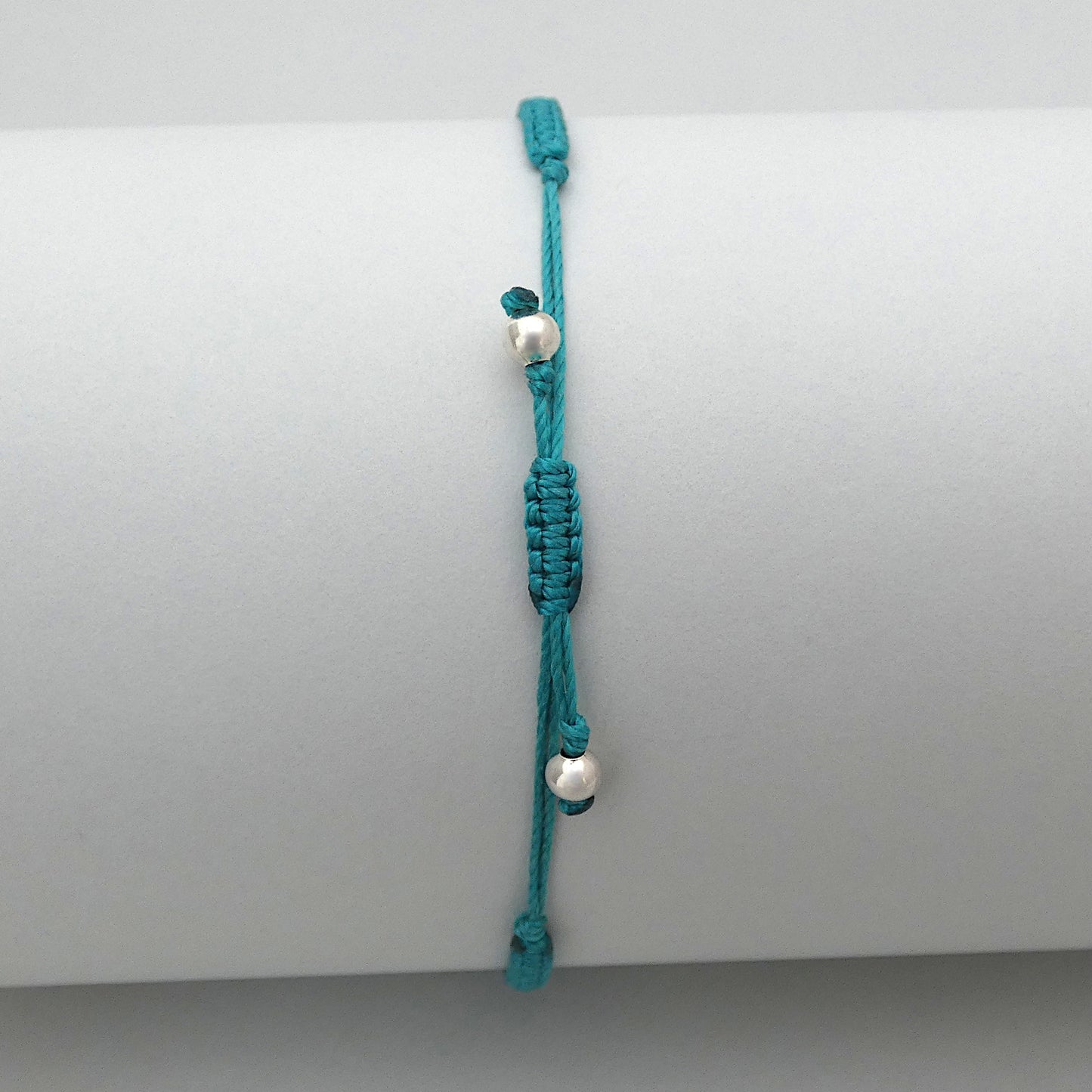 7” adjustable teal coloured macramé bracelet for adults with silver plated bead ends.