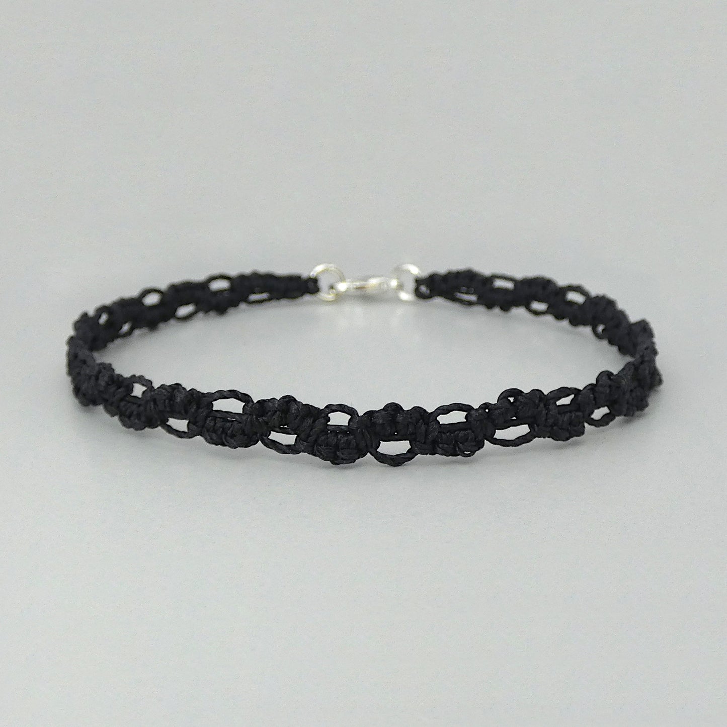 Black macramé bracelet tied with an intricate lace effect with silver plated clasp and optional 1” extender chain.