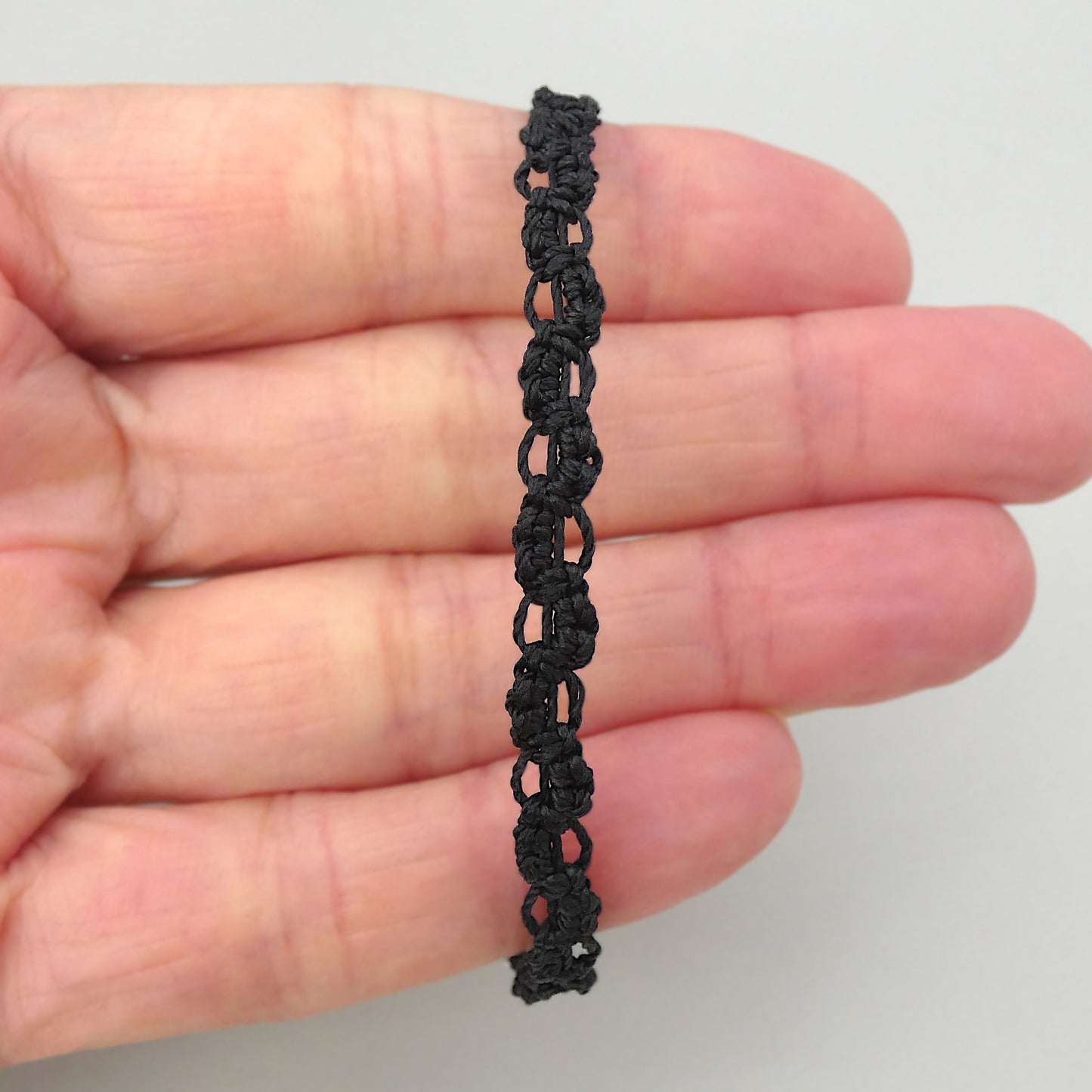 Black macramé bracelet tied with an intricate lace effect with silver plated clasp and optional 1” extender chain.