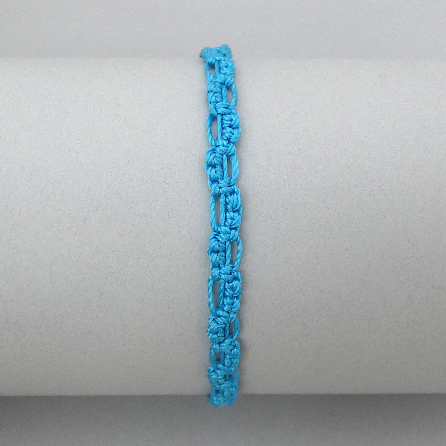 Bermuda blue macramé bracelet tied with an intricate lace effect with silver plated clasp and optional 1” extender chain.