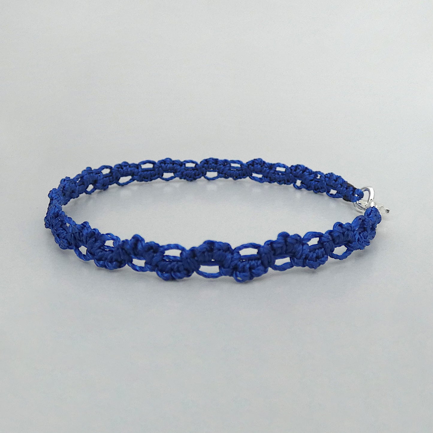 Royal blue macramé bracelet tied with an intricate lace effect with silver plated clasp and optional 1” extender chain.