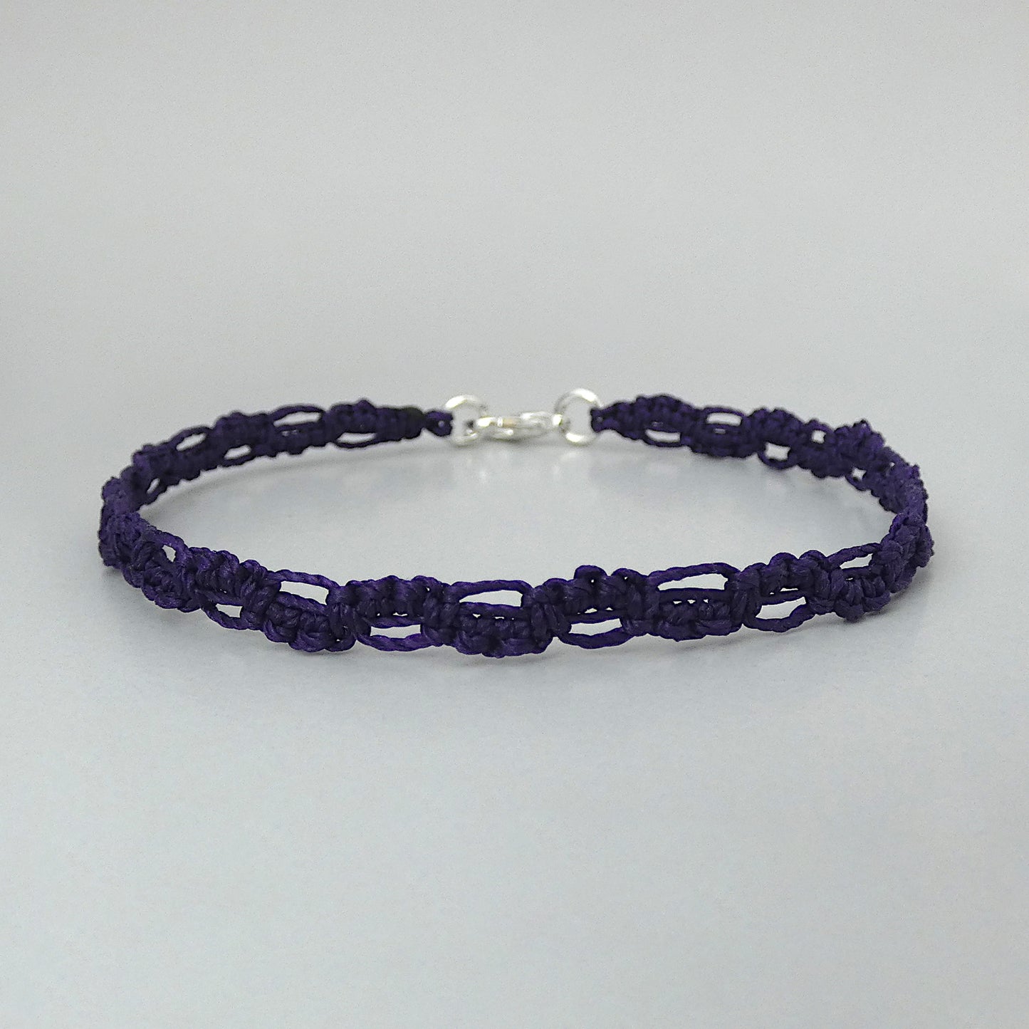 Dark purple macramé bracelet tied with an intricate lace effect with silver plated clasp and optional 1” extender chain.