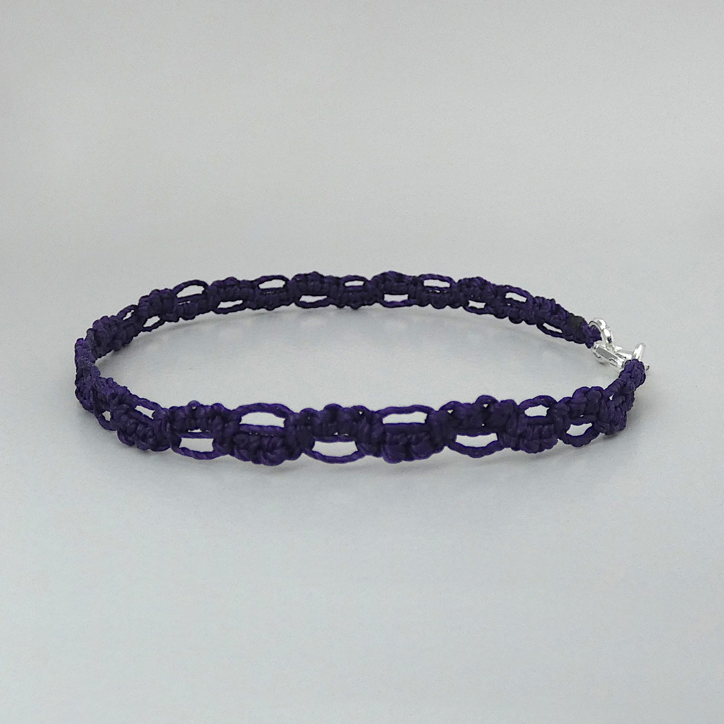 Dark purple macramé bracelet tied with an intricate lace effect with silver plated clasp and optional 1” extender chain.