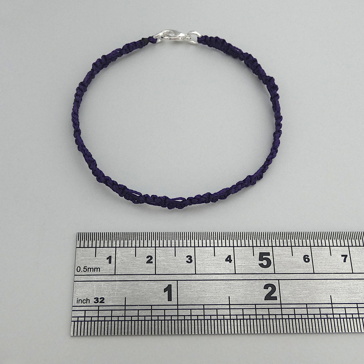 Dark purple macramé bracelet tied with an intricate lace effect with silver plated clasp and optional 1” extender chain.