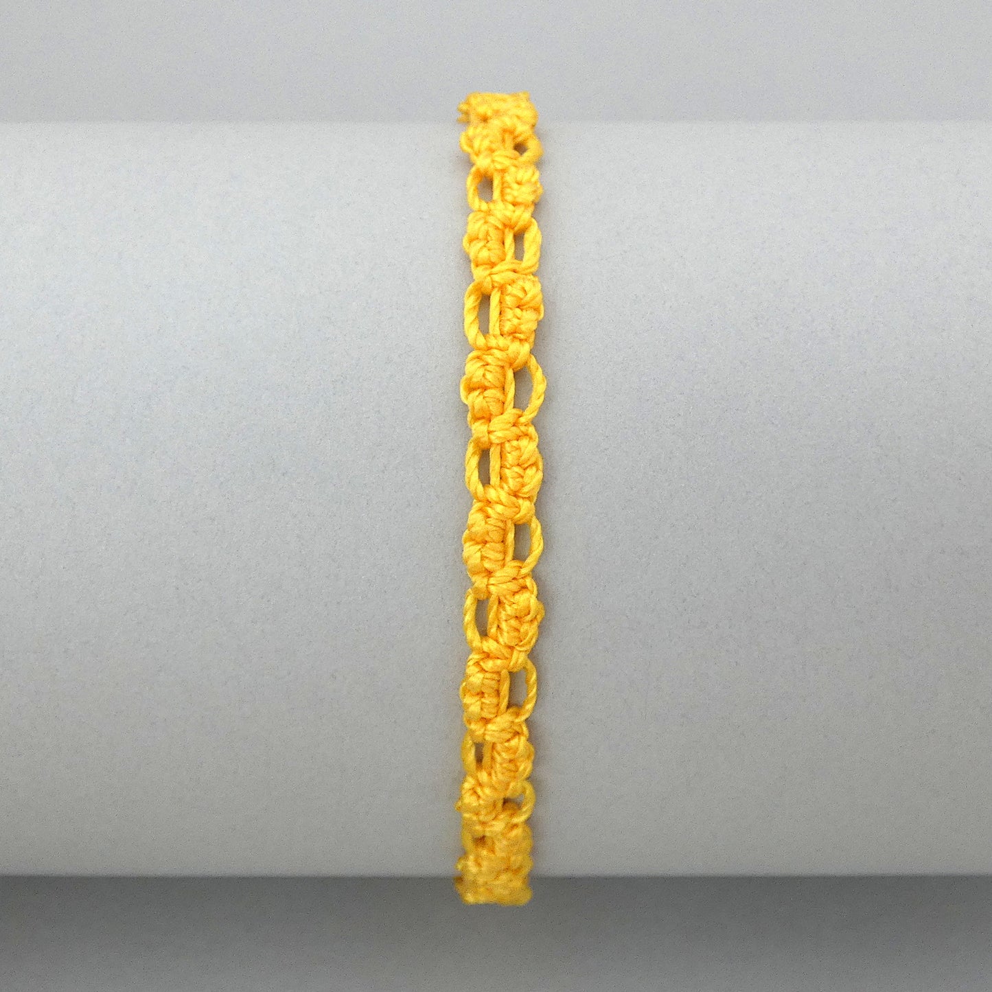 Golden yellow macramé bracelet tied with an intricate lace effect with silver plated clasp and optional 1” extender chain.
