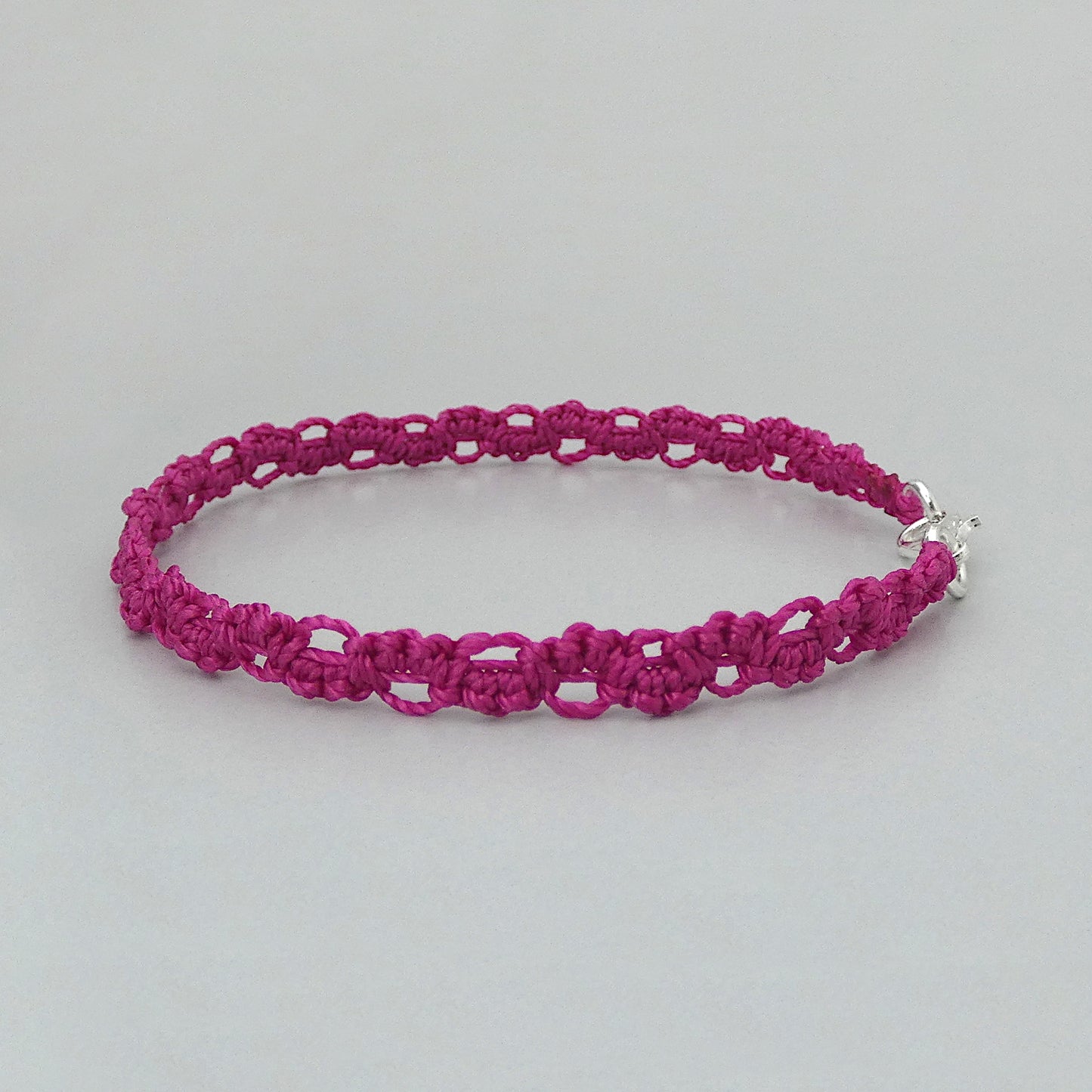 Magenta purple macramé bracelet tied with an intricate lace effect with silver plated clasp and optional 1” extender chain.
