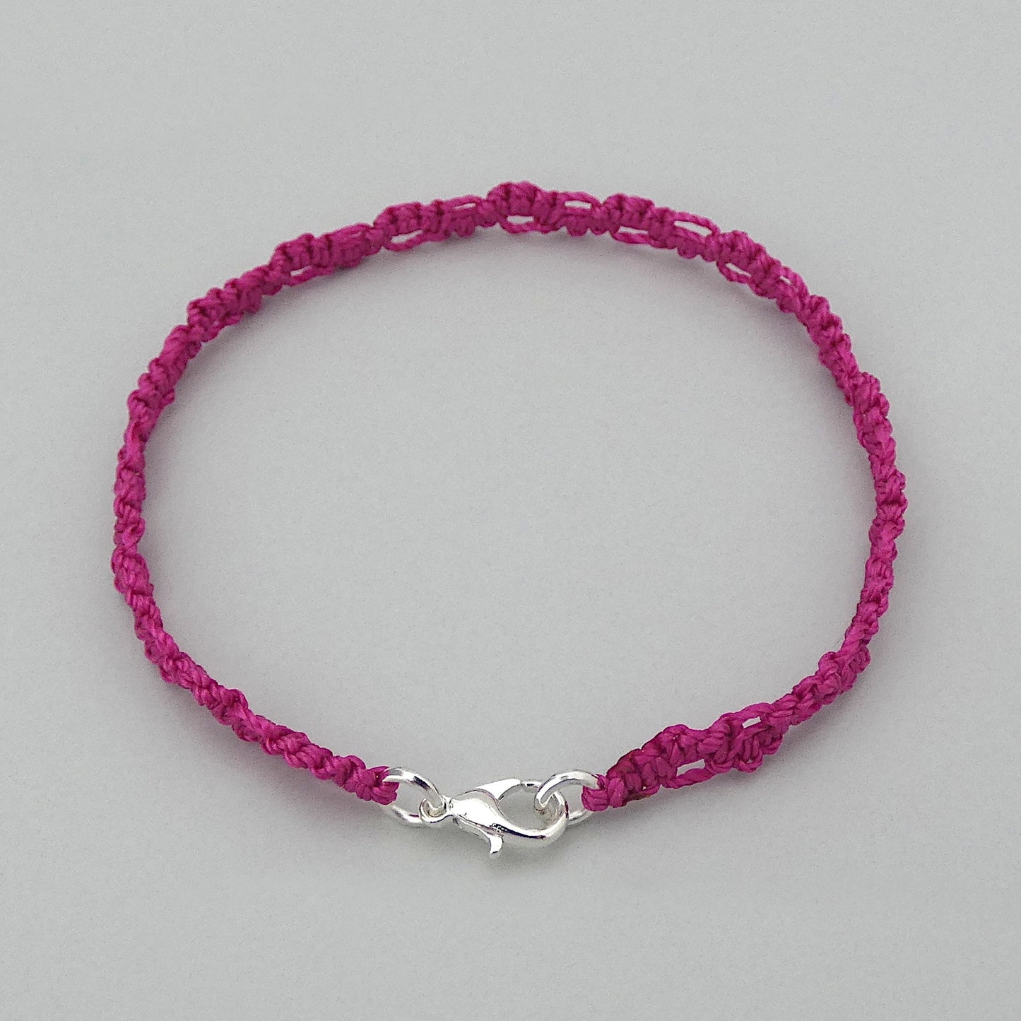 Magenta purple macramé bracelet tied with an intricate lace effect with silver plated clasp and optional 1” extender chain.