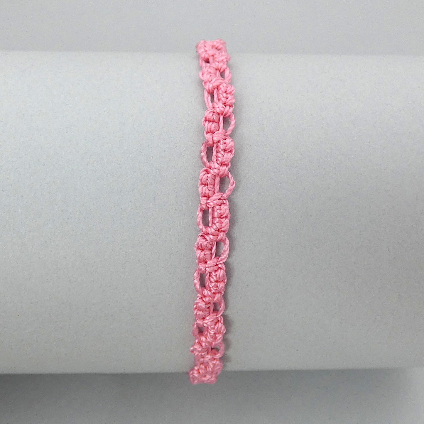 Pink macramé bracelet tied with an intricate lace effect with silver plated clasp and optional 1” extender chain.