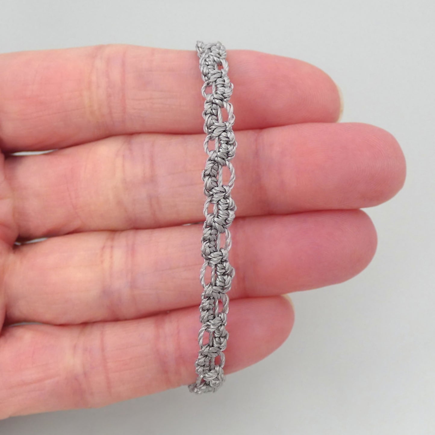 Silver grey macramé bracelet tied with an intricate lace effect with silver plated clasp and optional 1” extender chain.