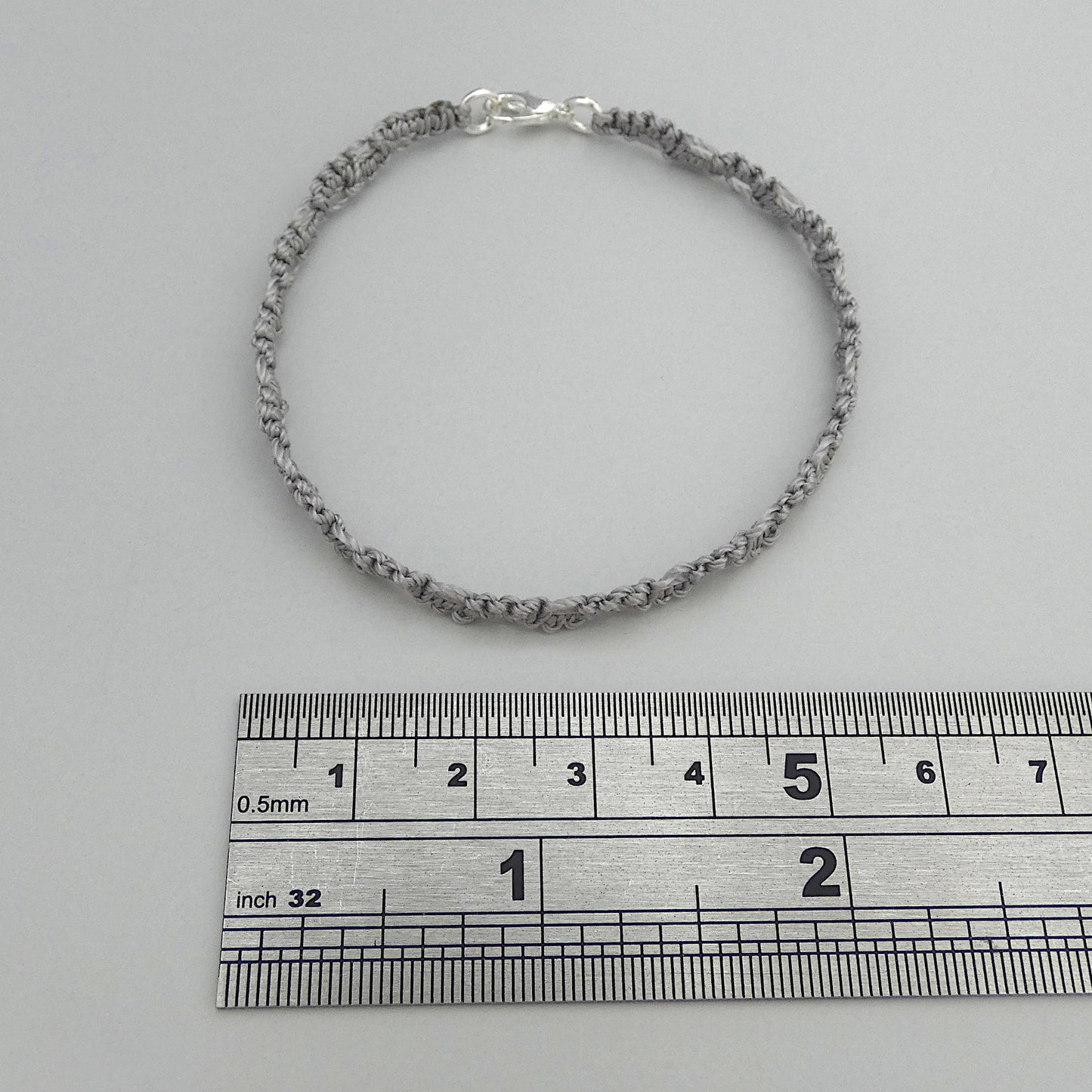 Silver grey macramé bracelet tied with an intricate lace effect with silver plated clasp and optional 1” extender chain.
