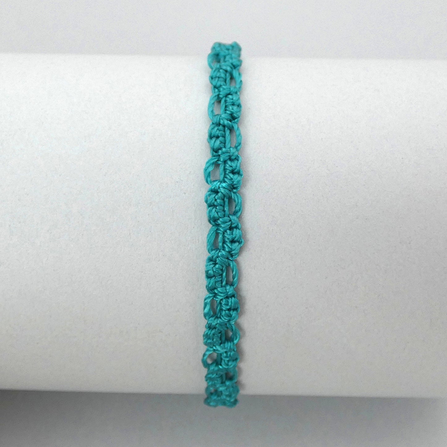 Teal green macramé bracelet tied with an intricate lace effect with silver plated clasp and optional 1” extender chain.