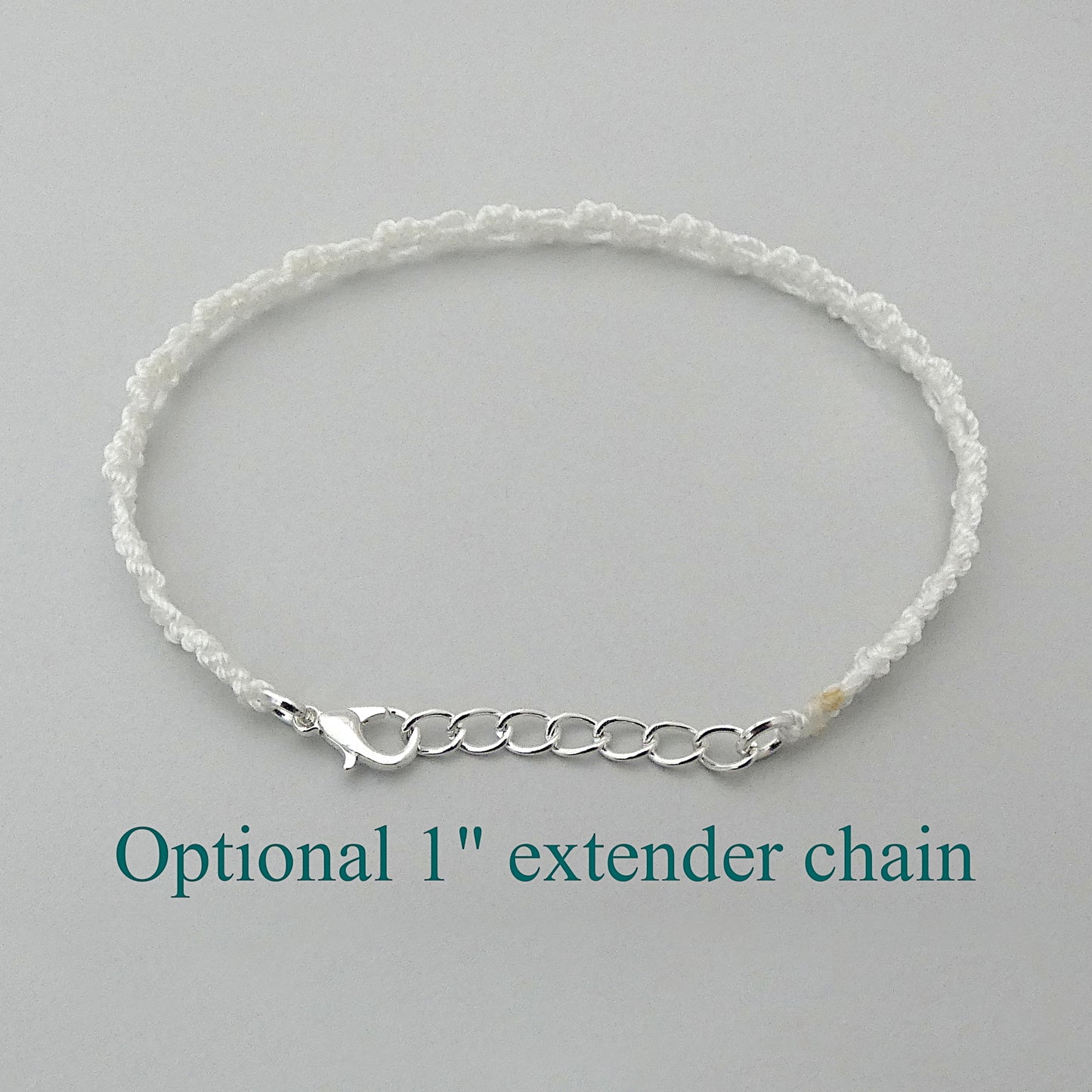 White macramé bracelet tied with an intricate wave effect with silver plated clasp and optional 1” extender chain.