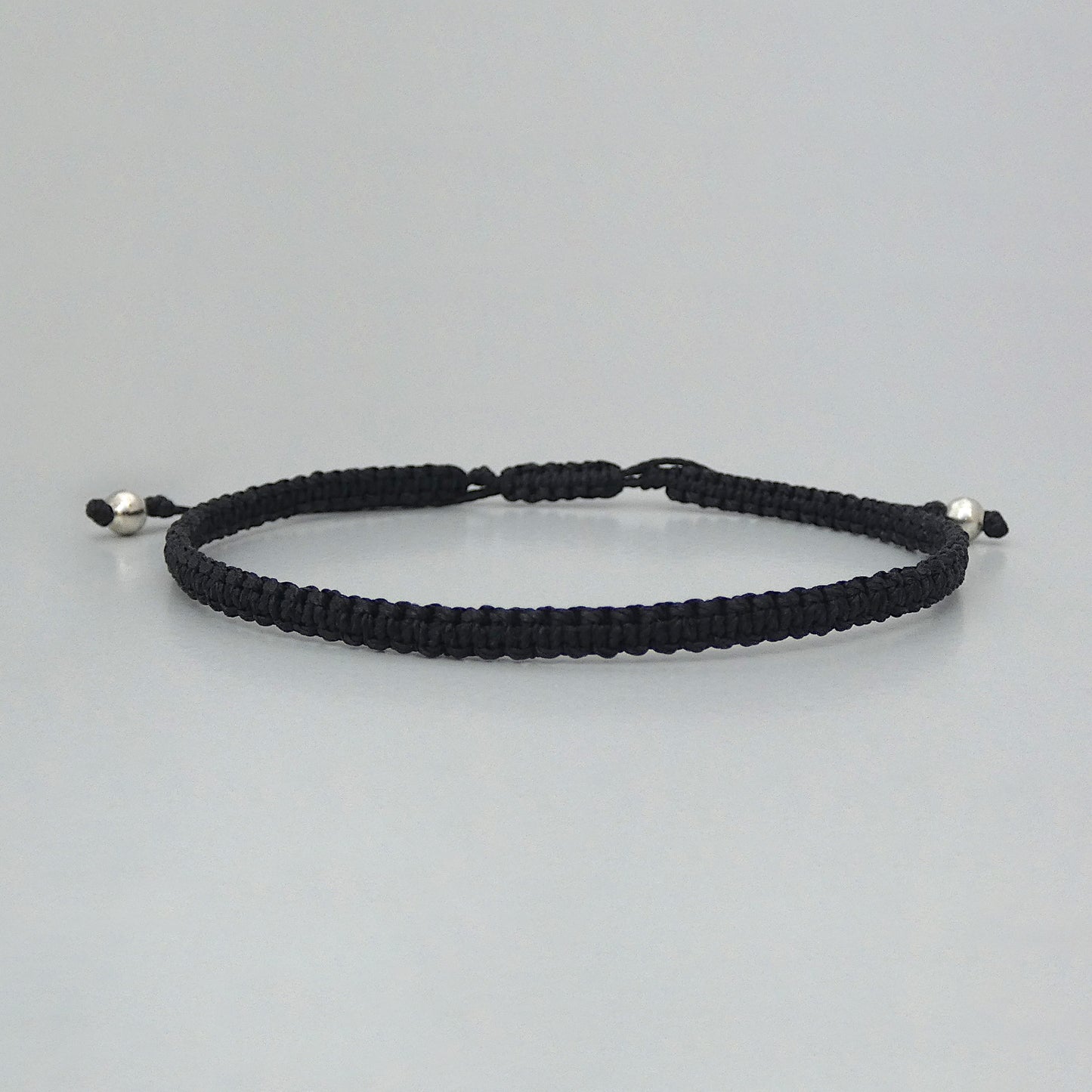 7” adjustable black coloured macramé bracelet for adults with silver plated bead ends.