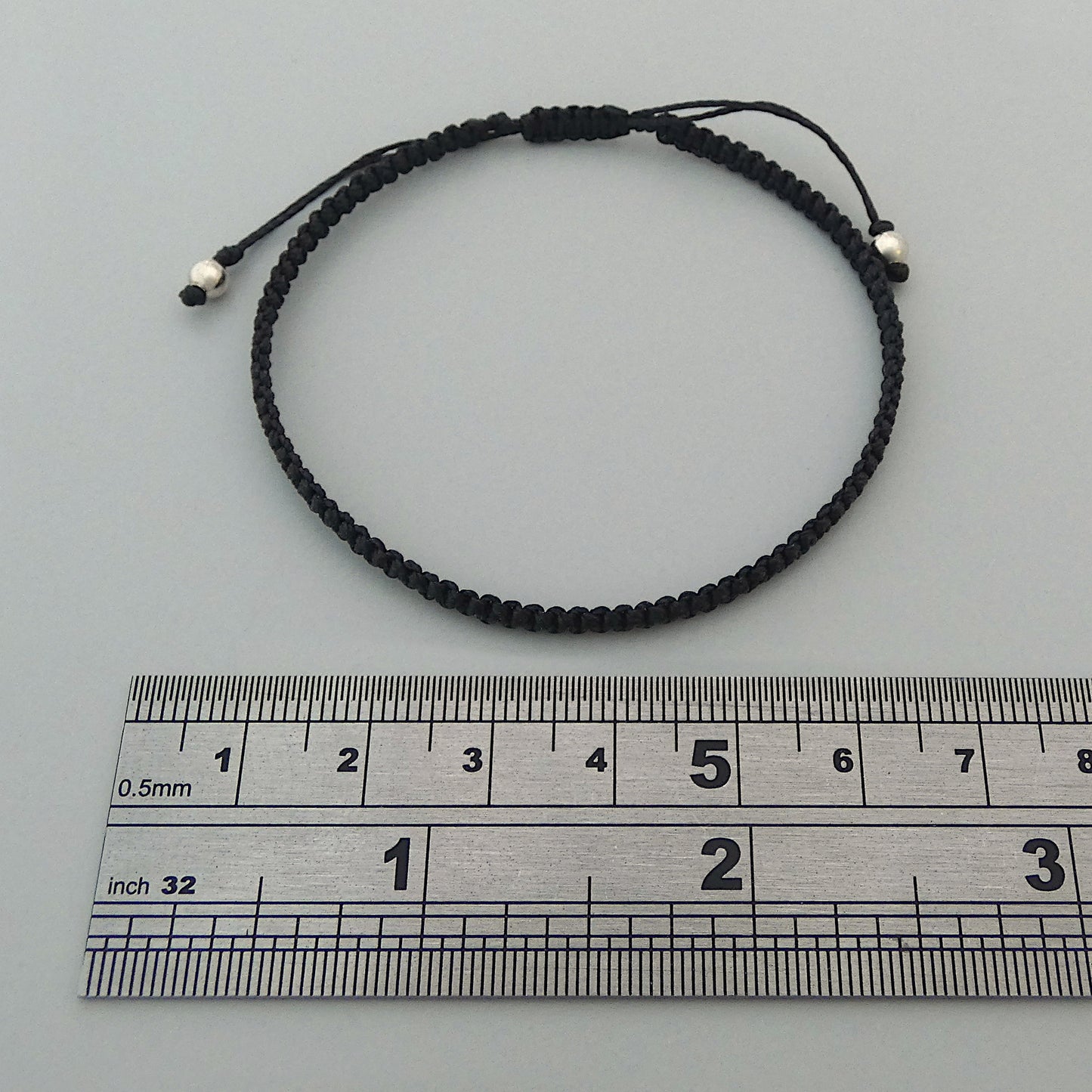 7” adjustable black coloured macramé bracelet for adults with silver plated bead ends.