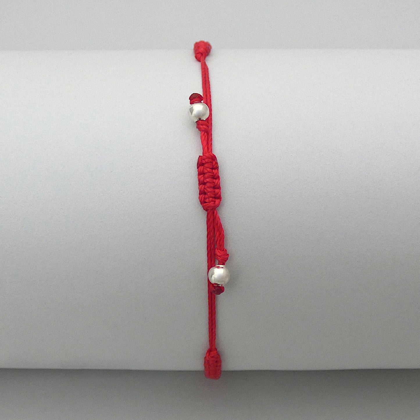 7” adjustable bright red coloured macramé bracelet for adults with silver plated bead ends.