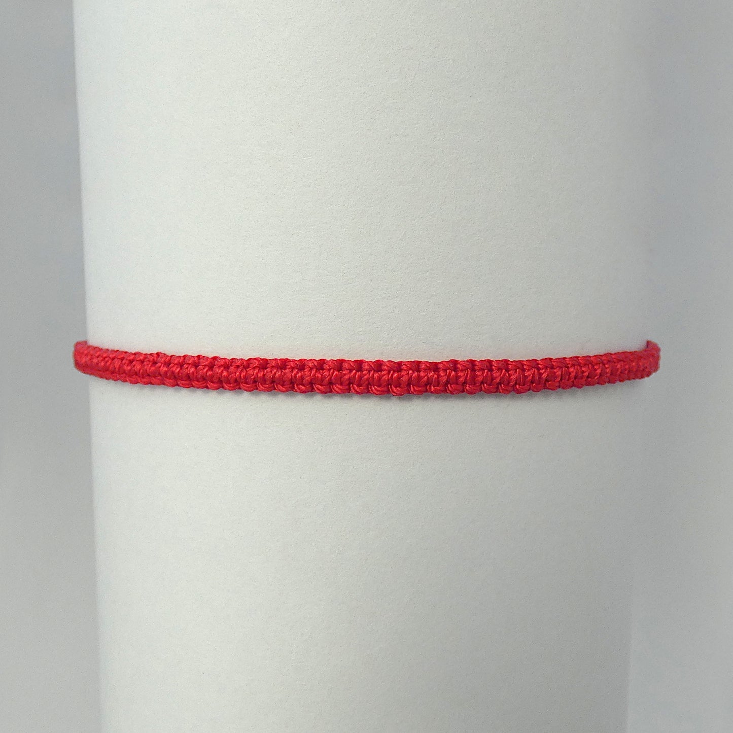 7” adjustable bright red coloured macramé bracelet for adults with silver plated bead ends.