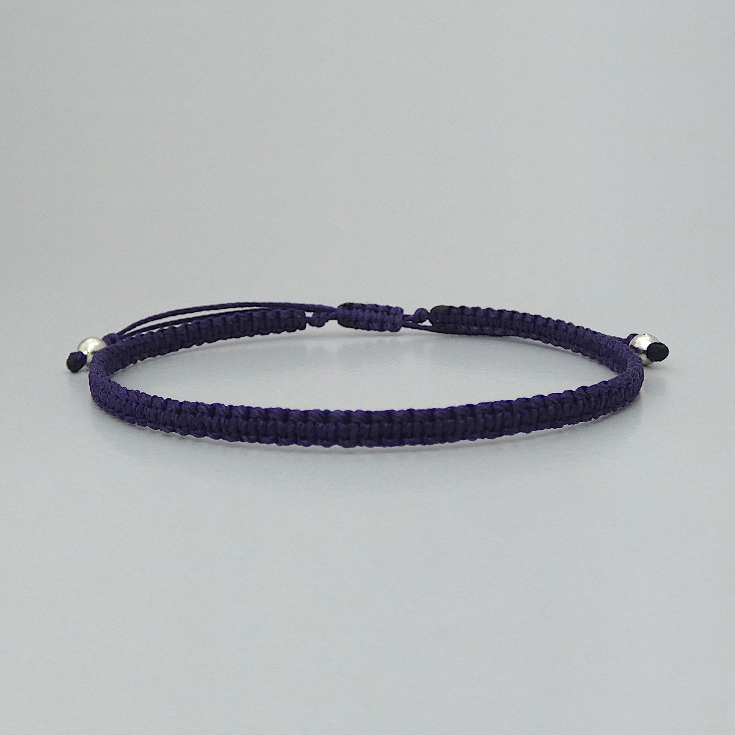 7” adjustable dark purple macramé bracelet for adults with silver plated bead ends.
