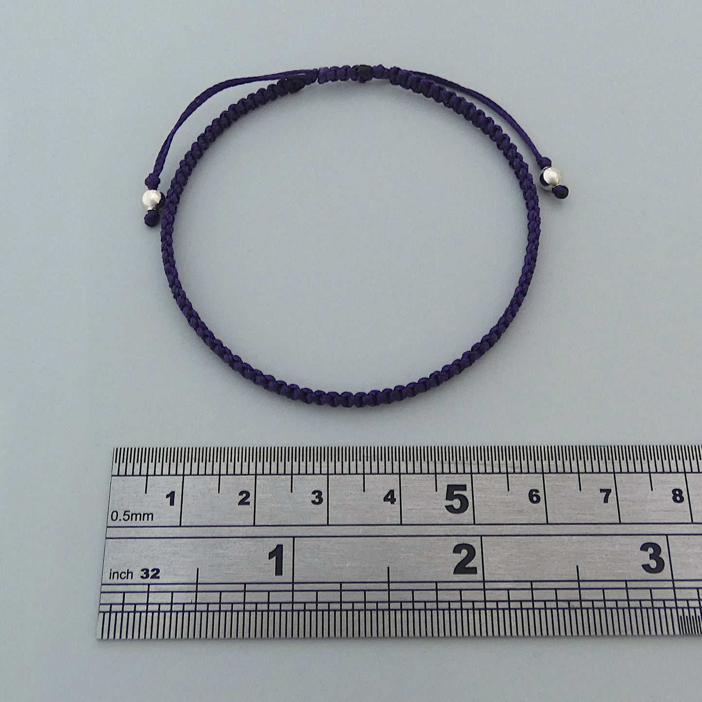 7” adjustable dark purple macramé bracelet for adults with silver plated bead ends.
