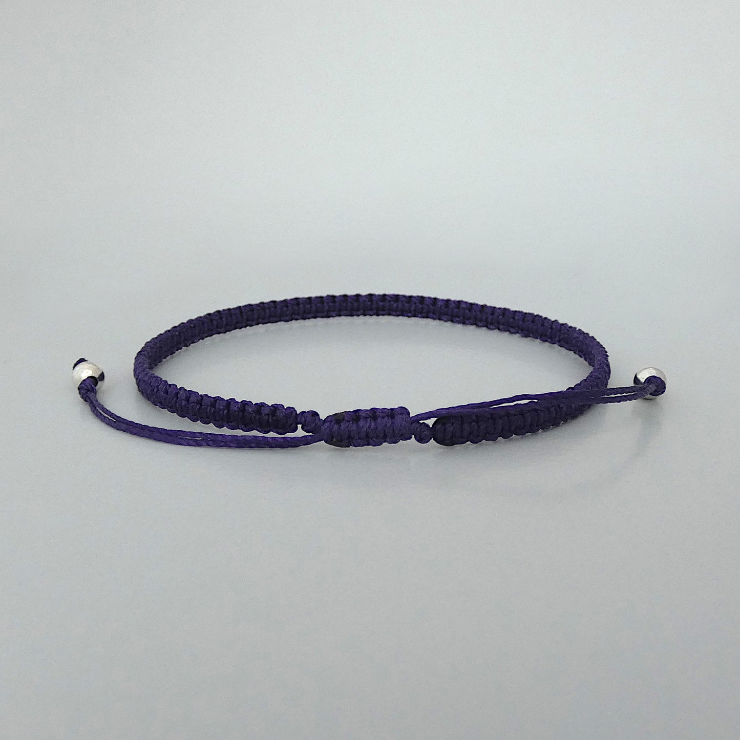 7” adjustable dark purple macramé bracelet for adults with silver plated bead ends.
