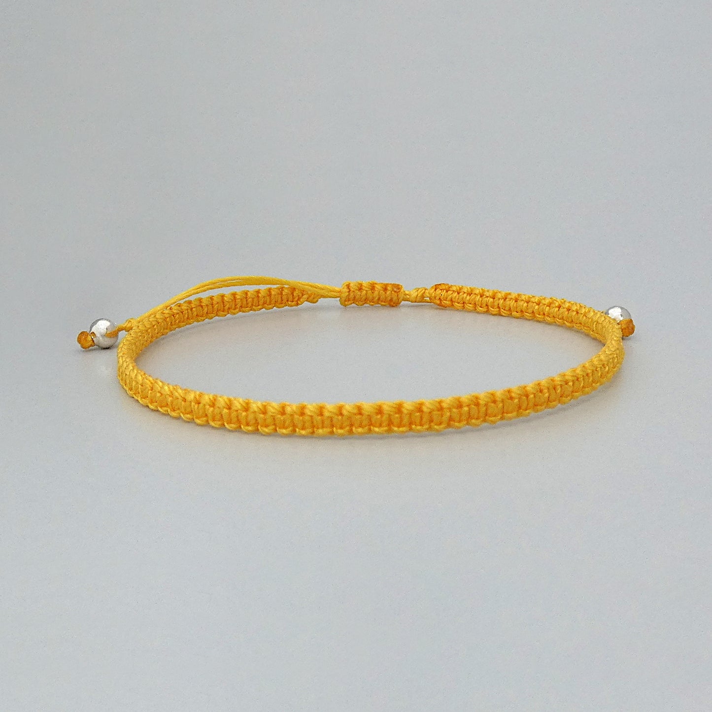 7” adjustable Golden yellow macramé bracelet for adults with silver plated bead ends.