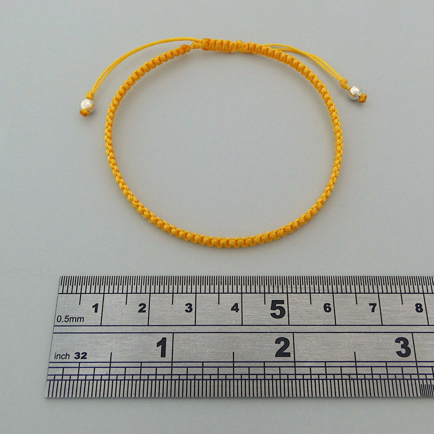 7” adjustable Golden yellow macramé bracelet for adults with silver plated bead ends.