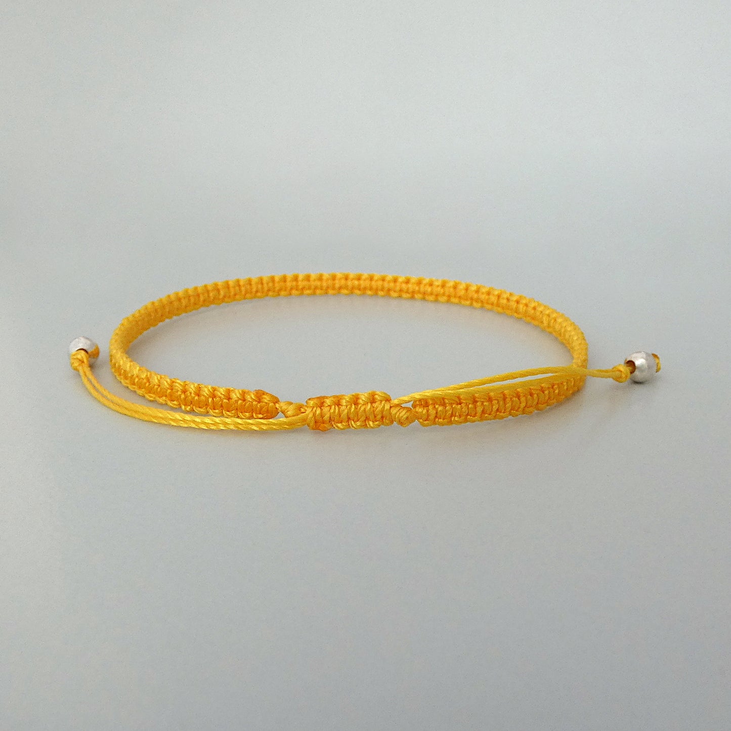 7” adjustable Golden yellow macramé bracelet for adults with silver plated bead ends.