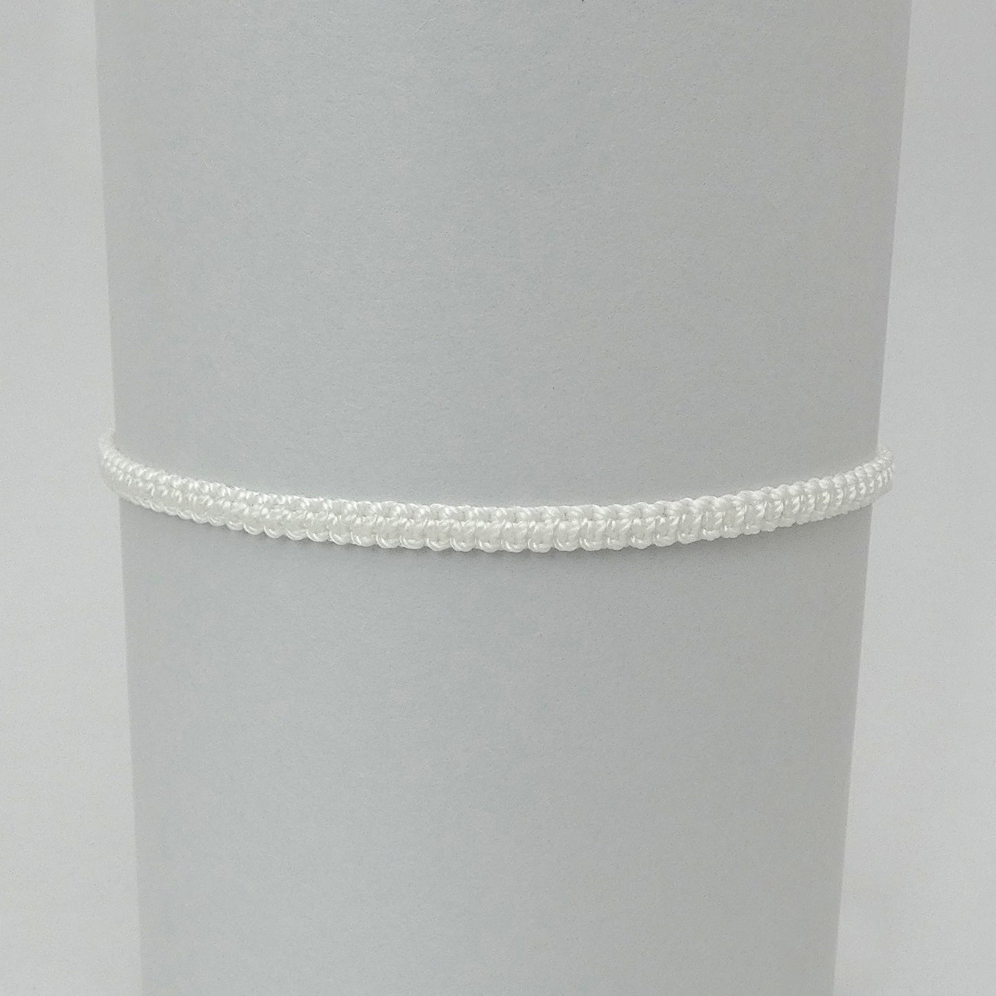 7” adjustable white macramé bracelet for adults with silver plated bead ends.