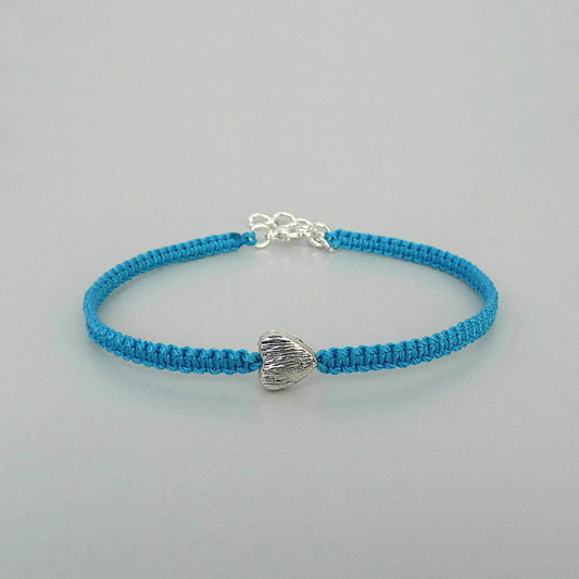 Blue seven inch macramé bracelet with silver plated textured heart charm, lobster clasp and one inch extender chain.