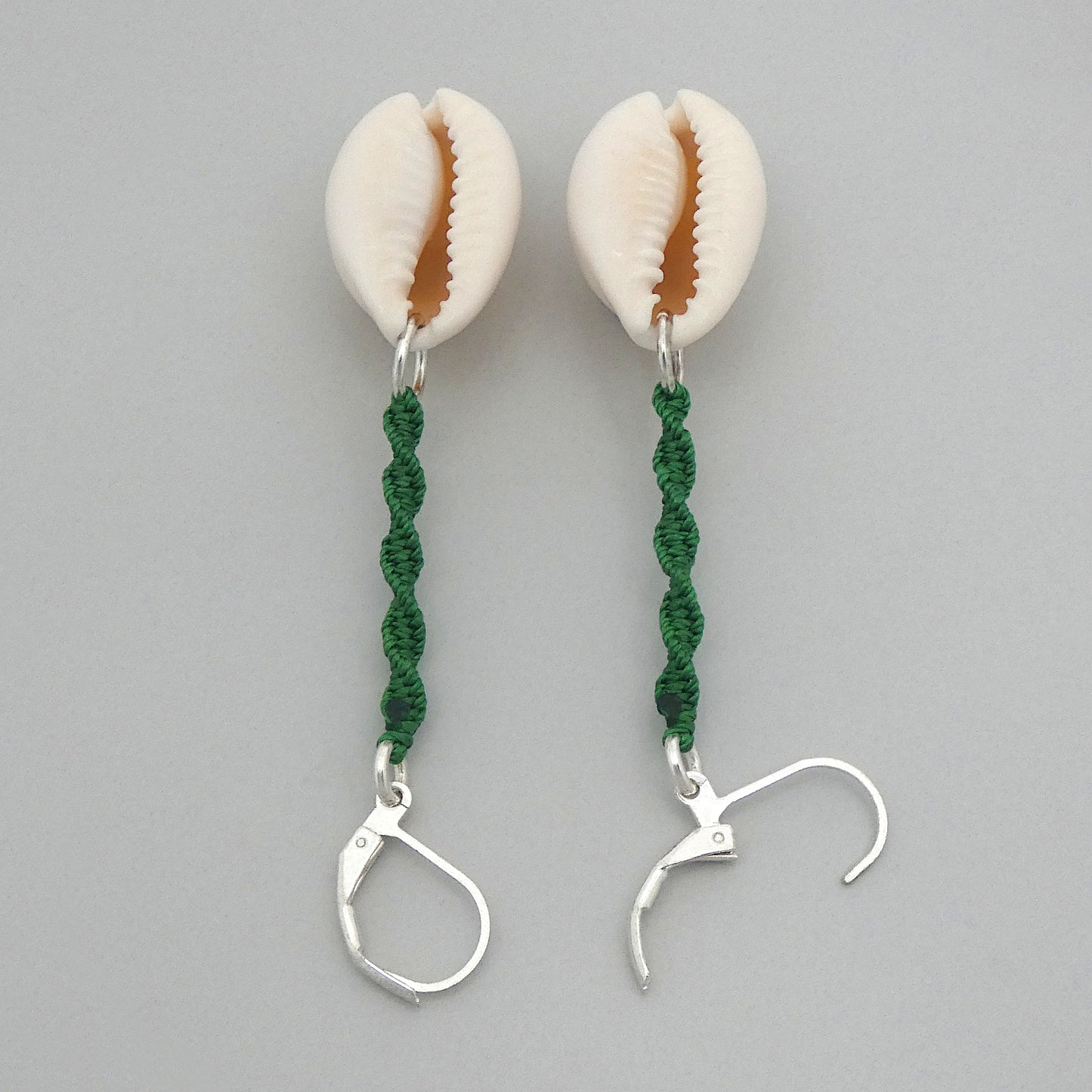 Silver plated leverback earrings with cowrie shells and green macramé twist detail.