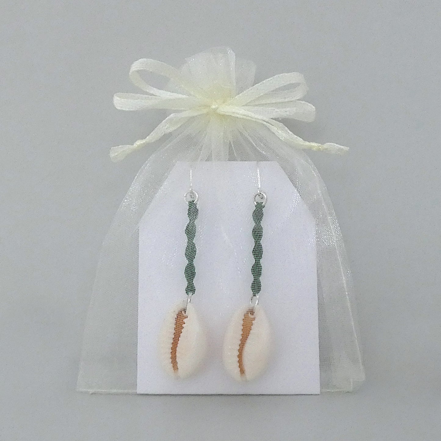 Silver plated leverback earrings with cowrie shells and green macramé twist detail.