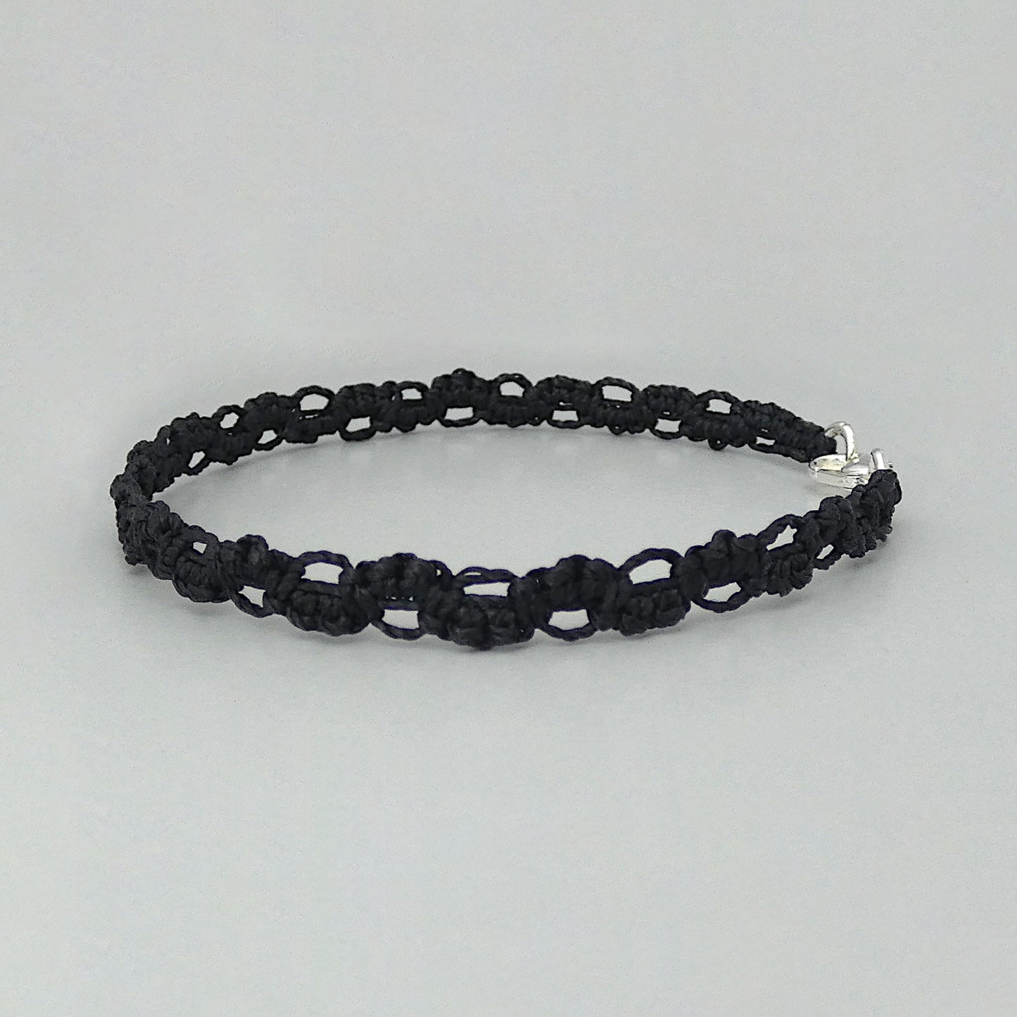 Black macramé bracelet tied with an intricate lace effect with silver plated clasp and optional 1” extender chain.