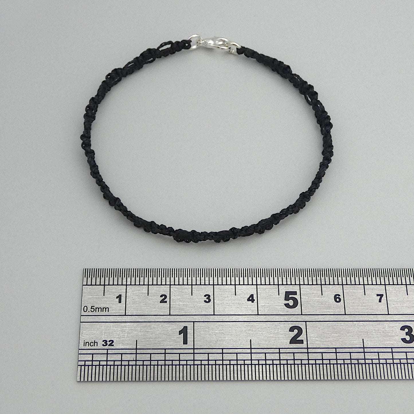 Black macramé bracelet tied with an intricate lace effect with silver plated clasp and optional 1” extender chain.