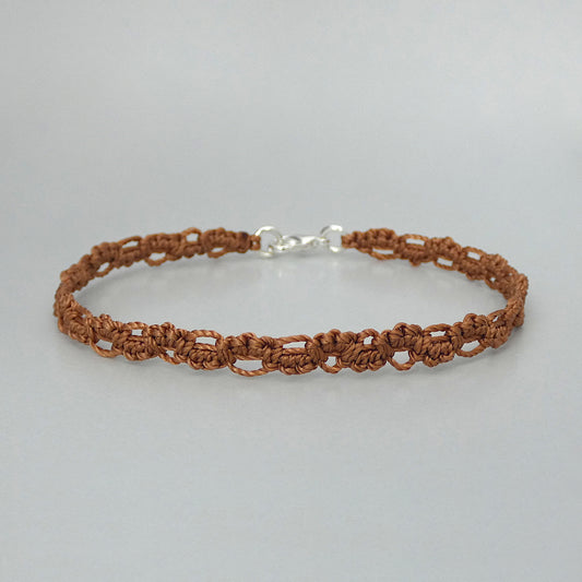 Copper coloured macramé bracelet tied with an intricate lace effect with silver plated clasp and optional 1” extender chain.