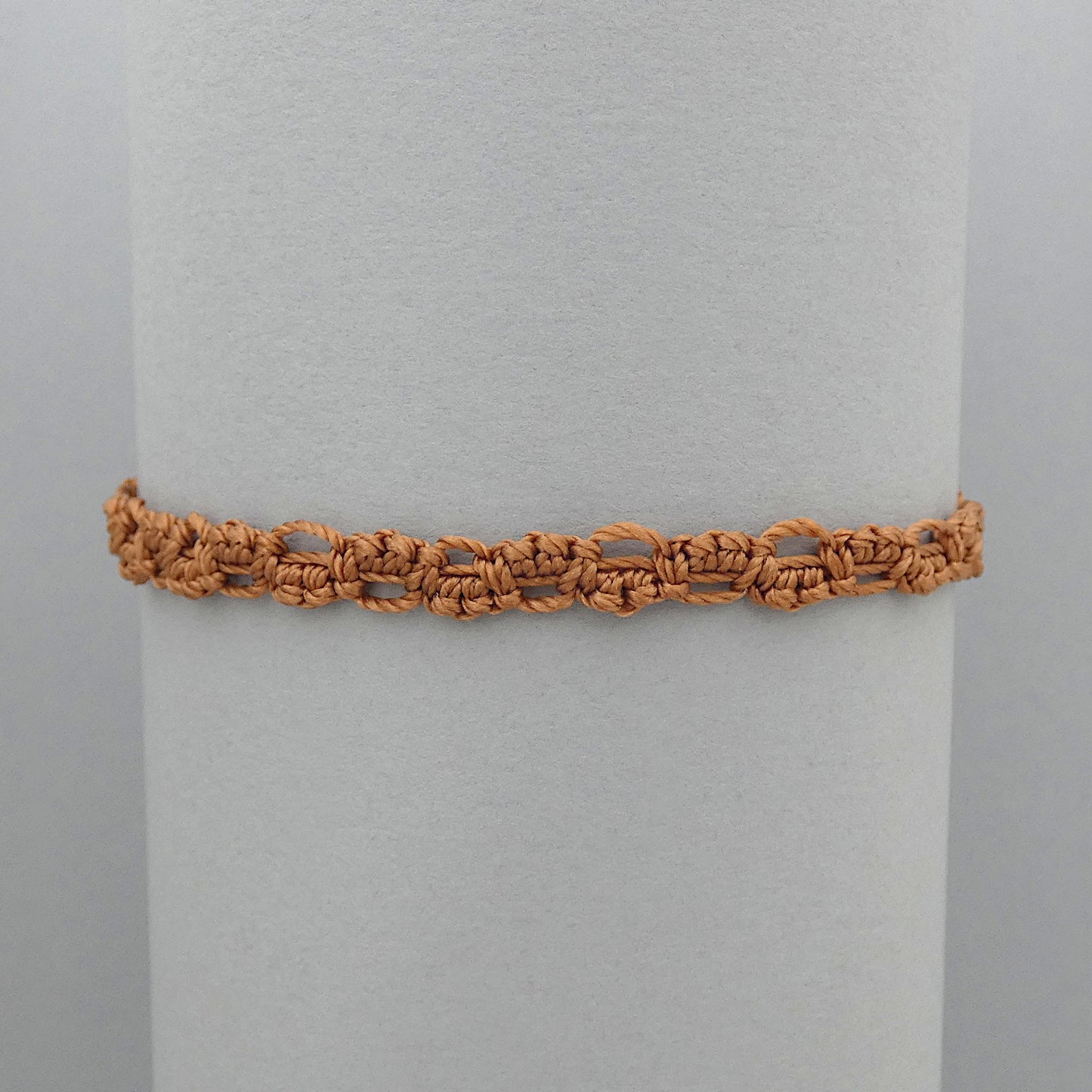 Copper coloured macramé bracelet tied with an intricate lace effect with silver plated clasp and optional 1” extender chain.