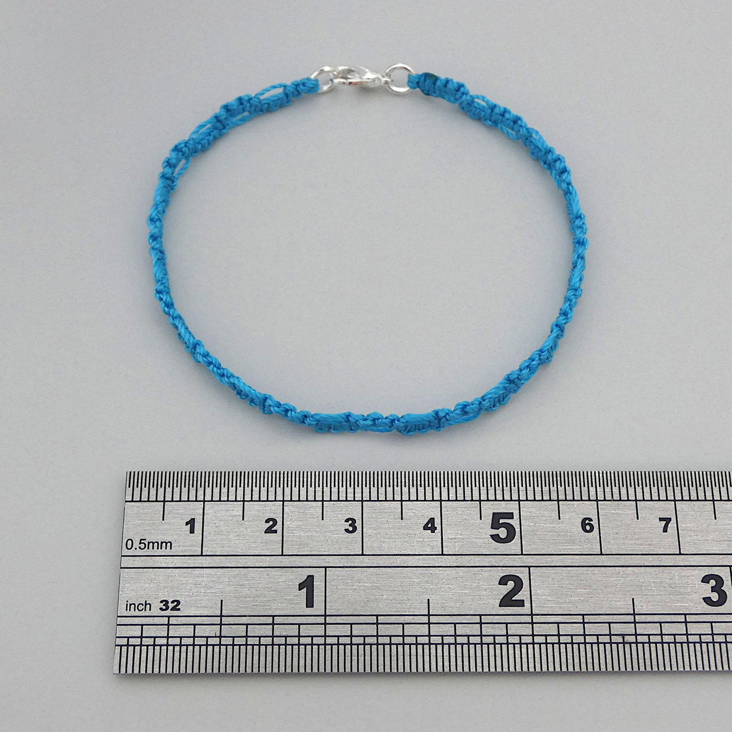 Bermuda blue macramé bracelet tied with an intricate lace effect with silver plated clasp and optional 1” extender chain.