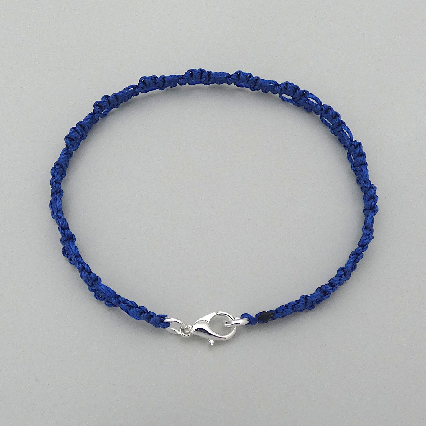 Royal blue macramé bracelet tied with an intricate lace effect with silver plated clasp and optional 1” extender chain.