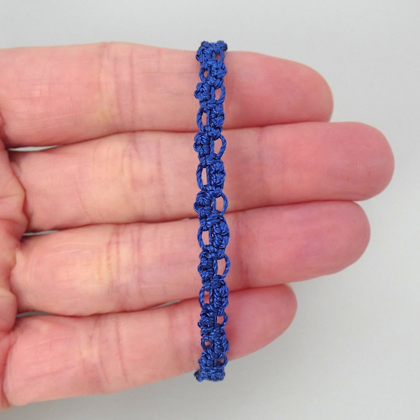 Royal blue macramé bracelet tied with an intricate lace effect with silver plated clasp and optional 1” extender chain.