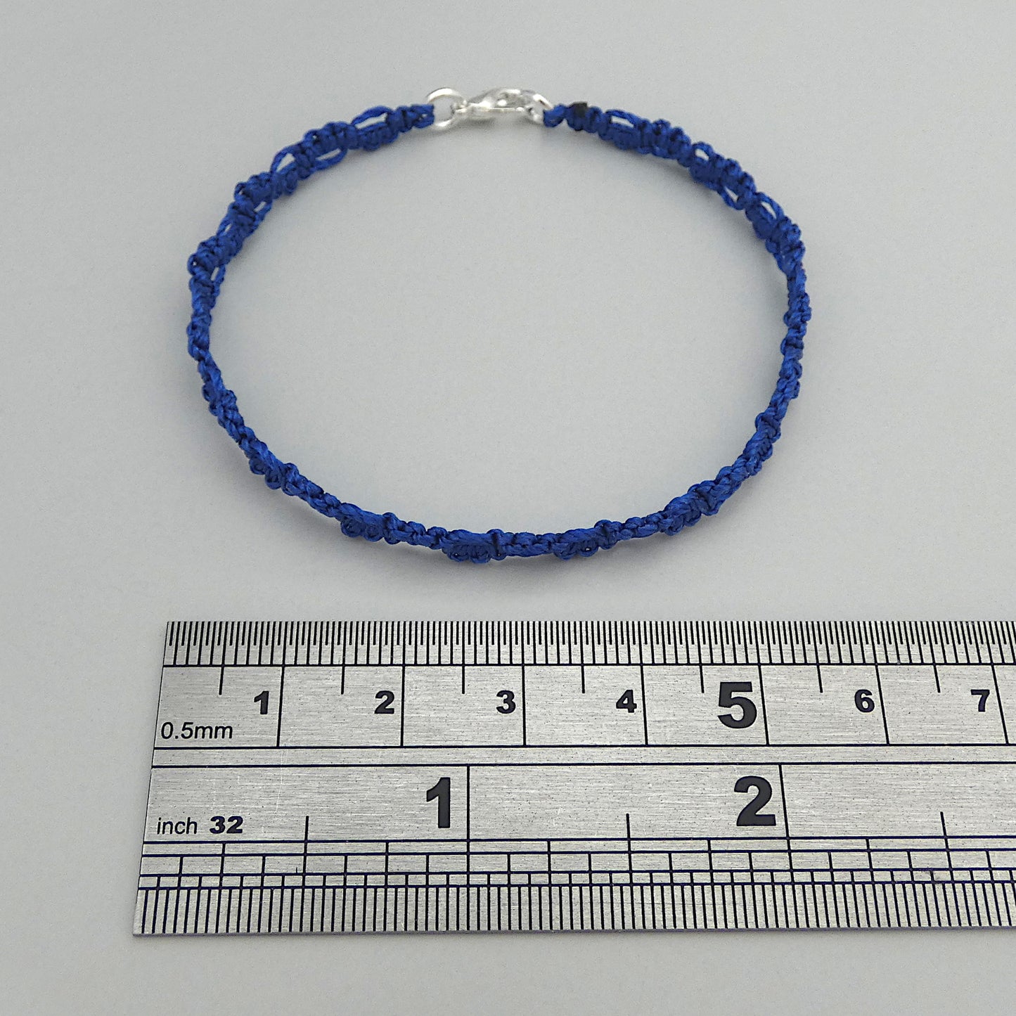 Royal blue macramé bracelet tied with an intricate lace effect with silver plated clasp and optional 1” extender chain.