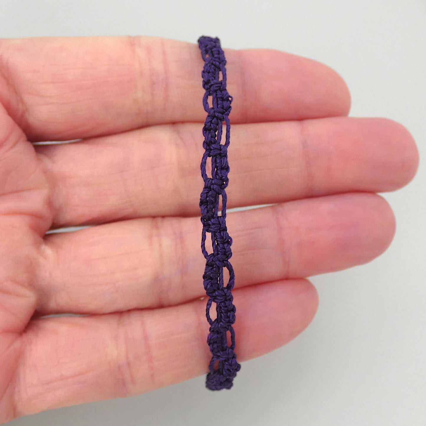 Dark purple macramé bracelet tied with an intricate lace effect with silver plated clasp and optional 1” extender chain.