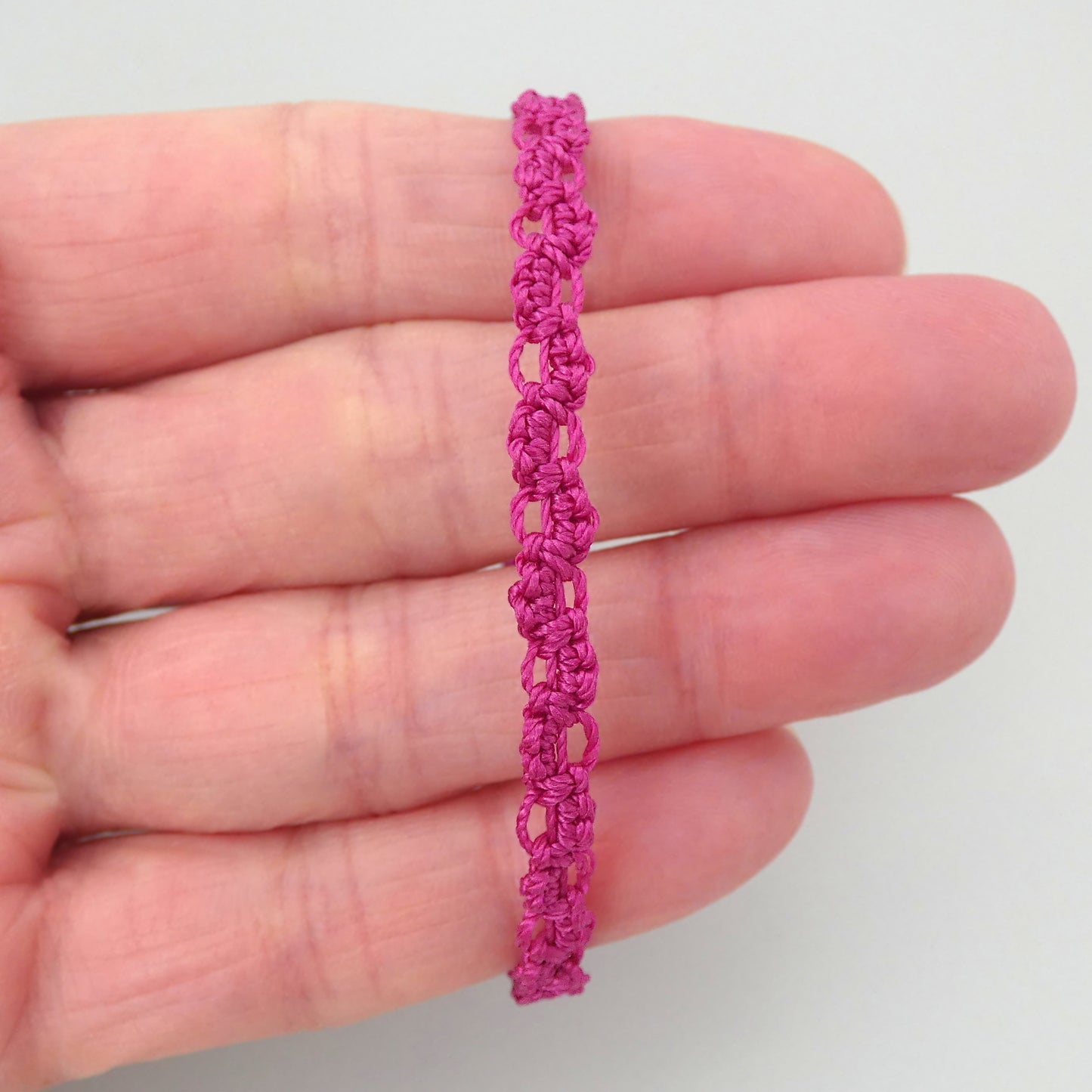 Magenta purple macramé bracelet tied with an intricate lace effect with silver plated clasp and optional 1” extender chain.