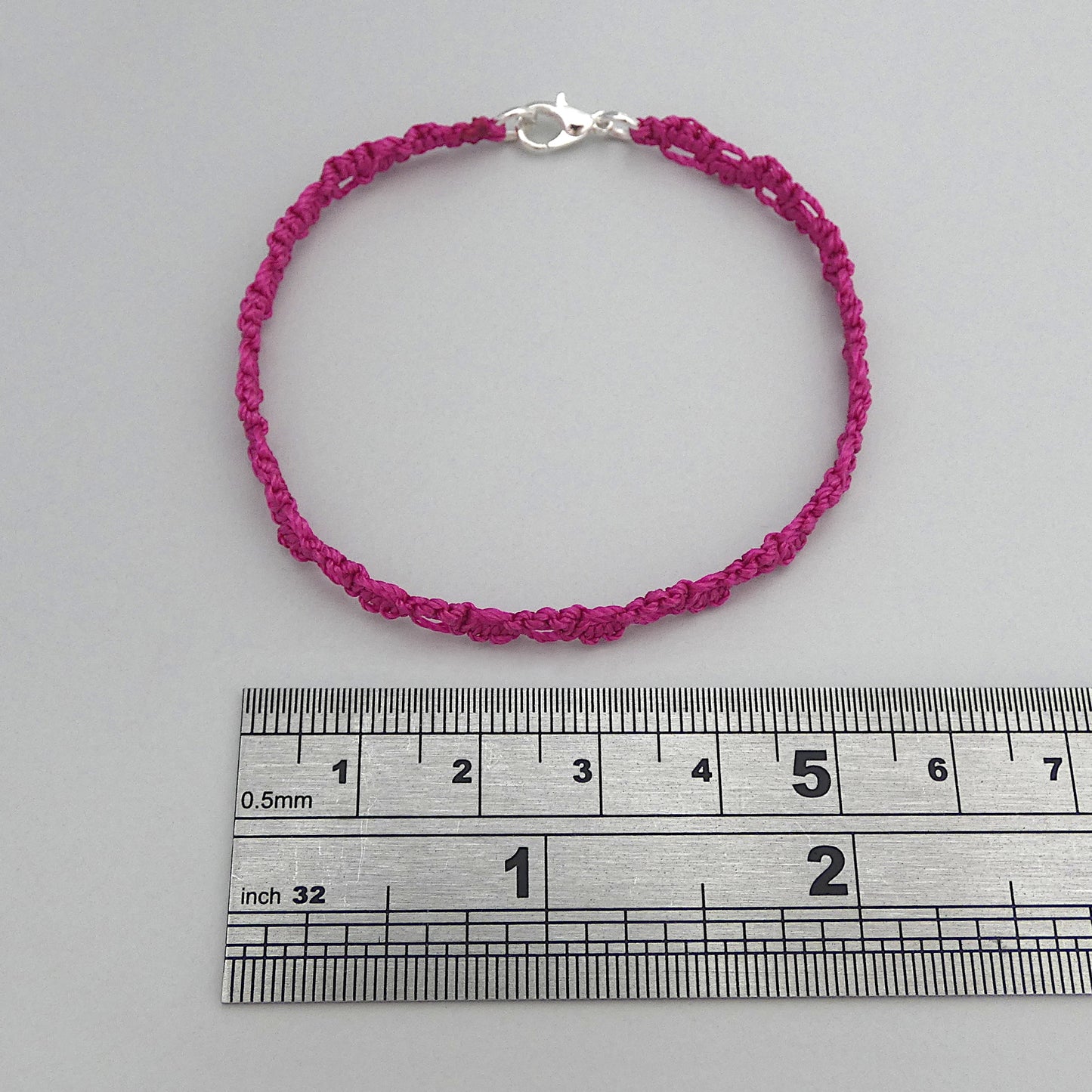Magenta purple macramé bracelet tied with an intricate lace effect with silver plated clasp and optional 1” extender chain.