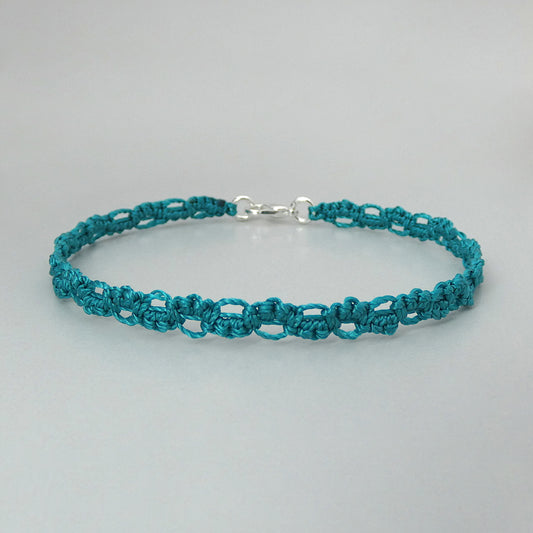 Teal green macramé bracelet tied with an intricate lace effect with silver plated clasp and optional 1” extender chain.