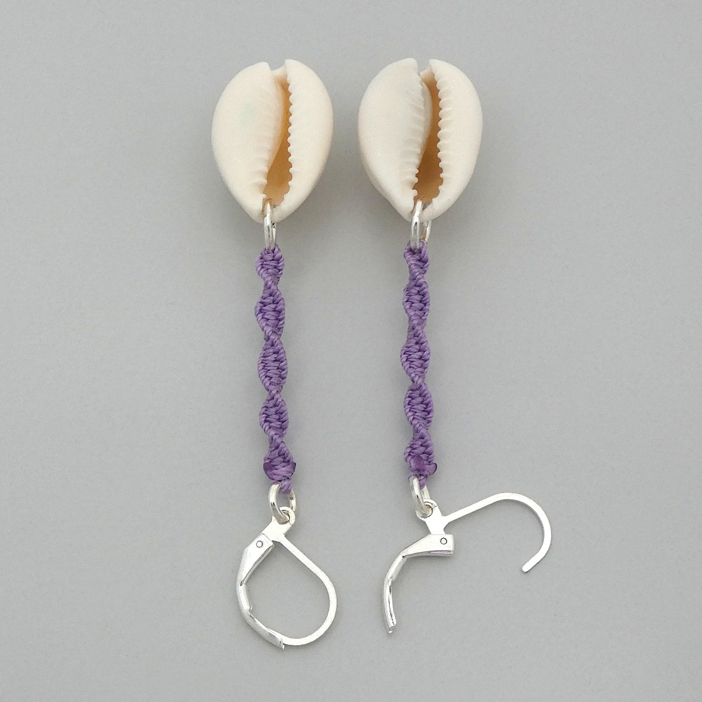 Silver plated leverback earrings with cowrie shells and orchid purple macramé twist detail.