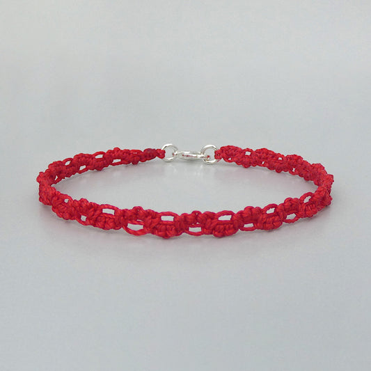 Red macramé bracelet tied with an intricate lace effect with silver plated clasp and optional 1” extender chain.